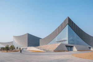 New Beijing Performing Arts Centre rises from its historic context with sweeping roof forms and a broad urban plinth