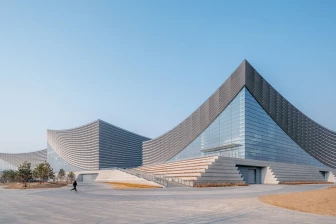 New Beijing Performing Arts Centre rises from its historic context with sweeping roof forms and a broad urban plinth