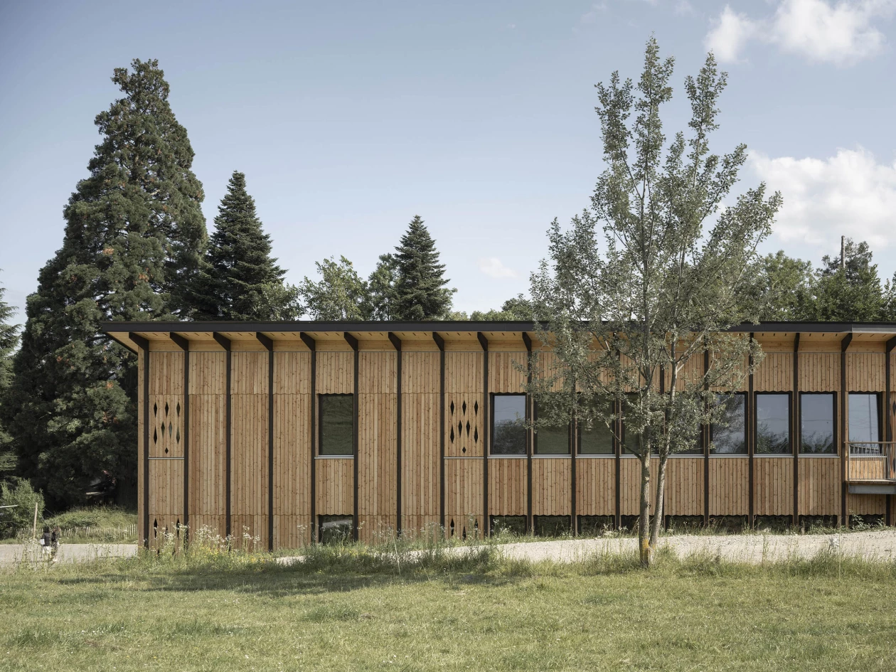 Swiss school expansion by LOCALARCHITECTURE features a flexible wooden framework and earth brick walls